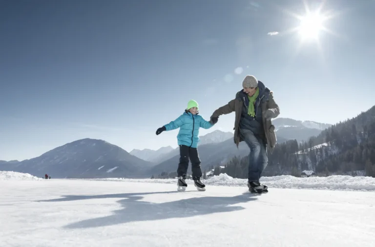 Vater mit Sohn beim Eislaufen am Weissensee