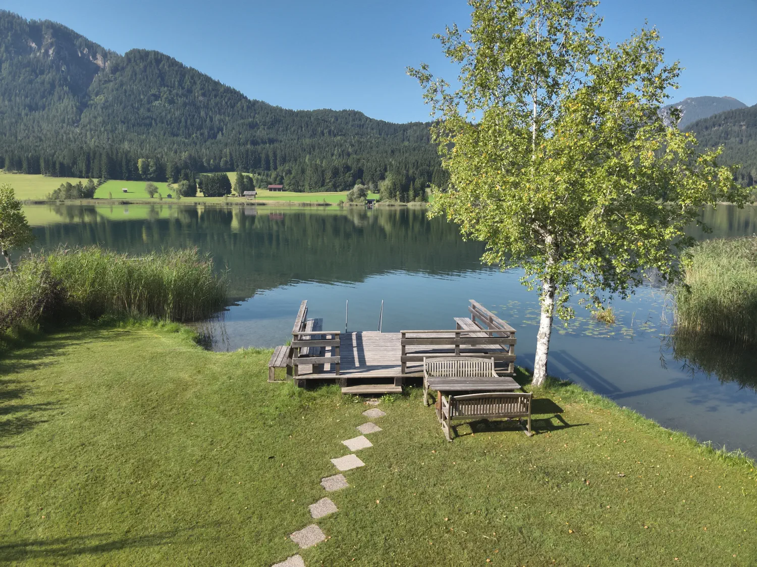 Blick von der Liegewiese auf den Steg und den Seezugang