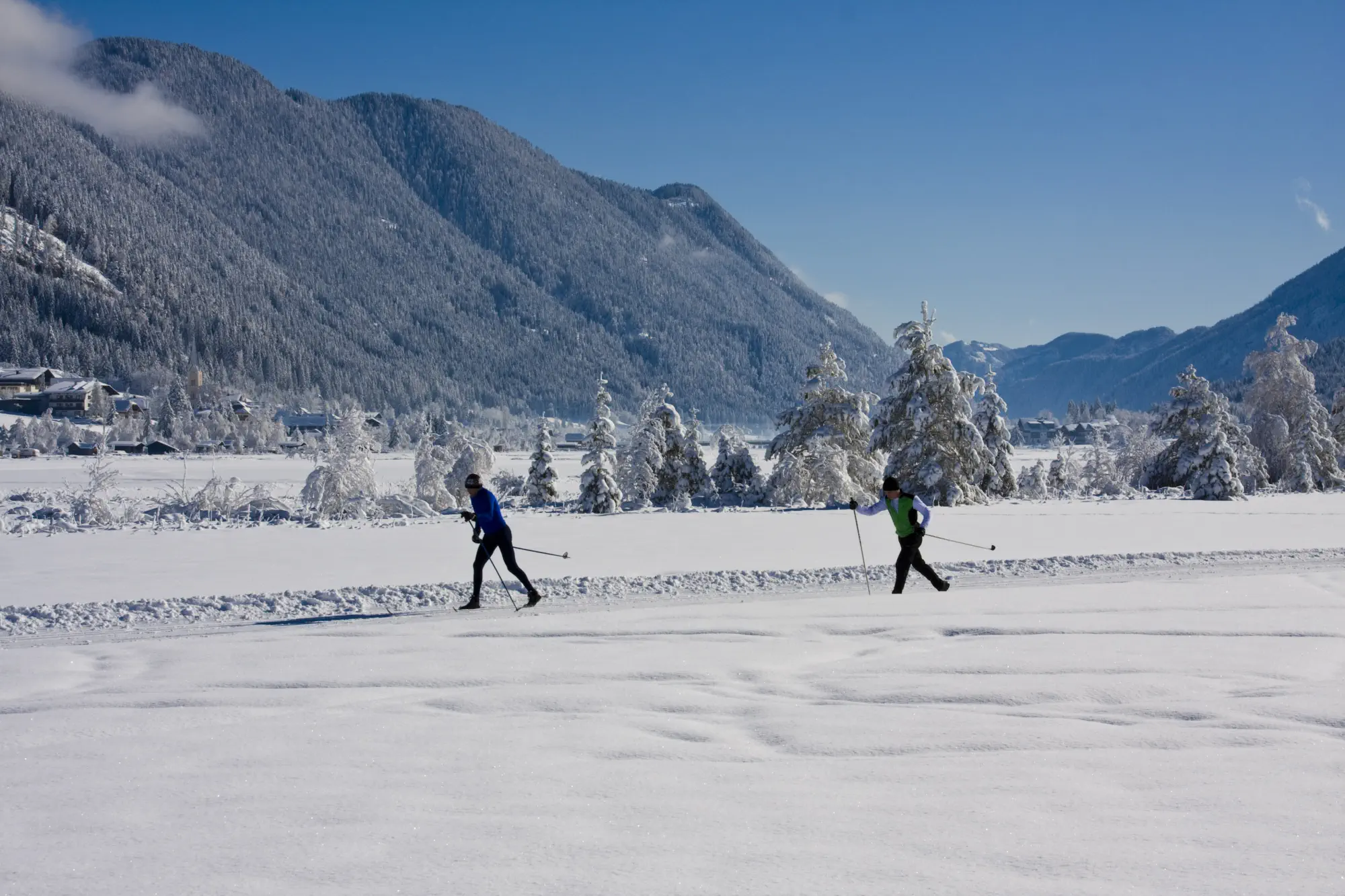Zwei Langläufer in der verschneiten Winterlandschaft